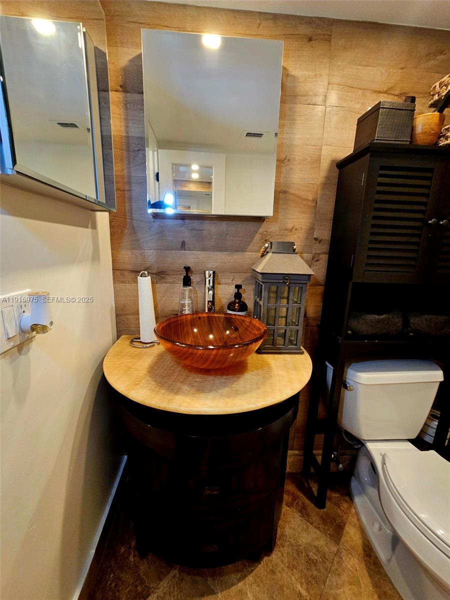 1800 North Andrews Avenue, Unit 2H Fort Lauderdale, FL 33311 - Photo 39 of 60 a bathroom with a sink a toilet and mirror