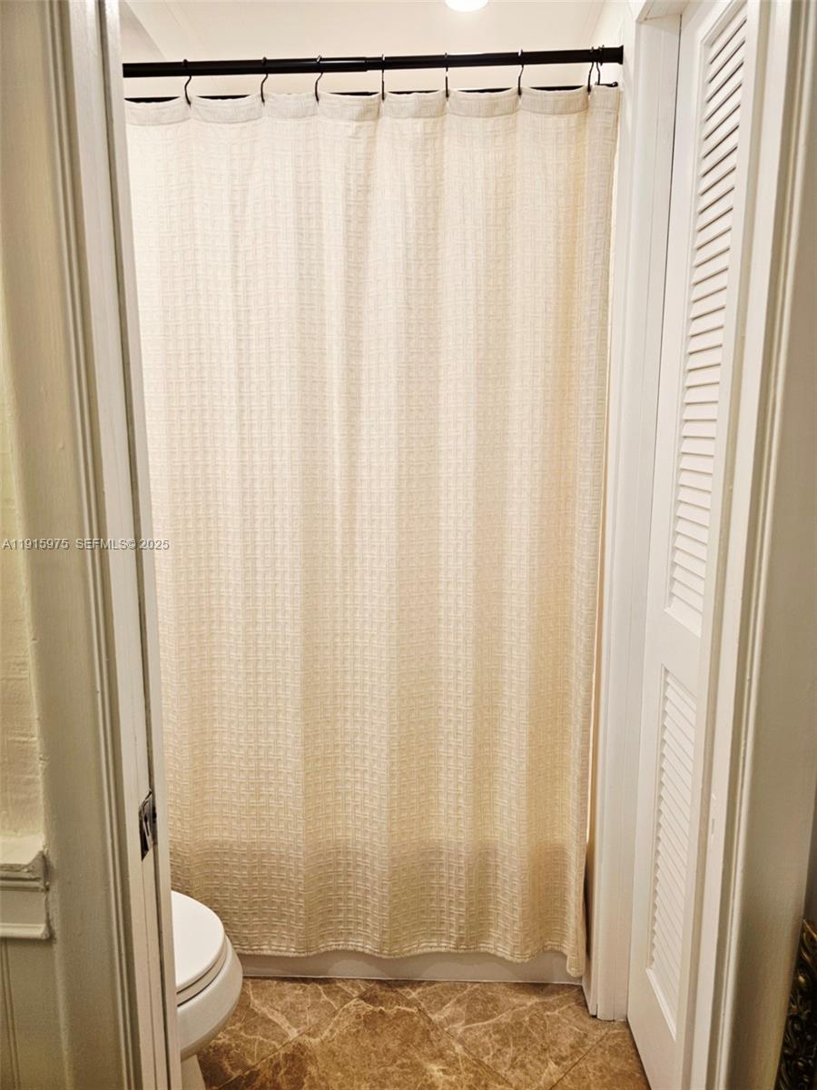 1800 North Andrews Avenue, Unit 2H Fort Lauderdale, FL 33311 - Photo 41 of 60 a bathroom with a shower curtain and sink