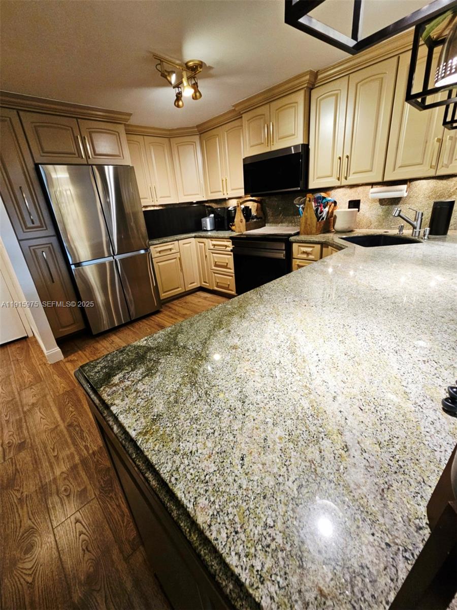 1800 North Andrews Avenue, Unit 2H Fort Lauderdale, FL 33311 - Photo 8 of 60 a kitchen with stainless steel appliances wooden cabinets a refrigerator and a sink