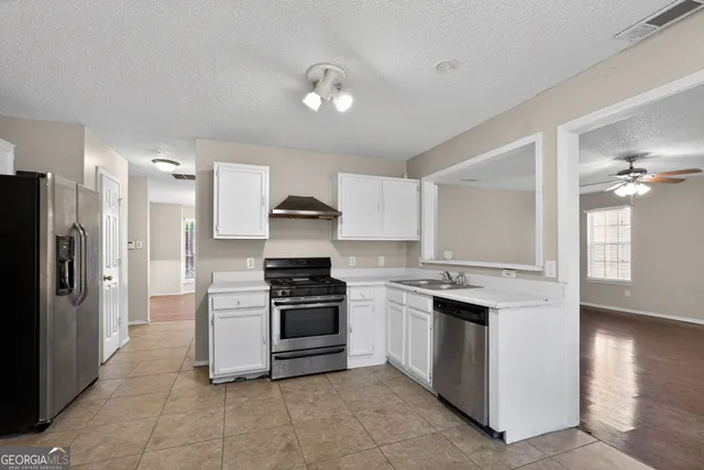 a kitchen with stainless steel appliances granite countertop a stove and a refrigerator