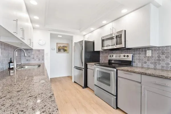 a kitchen with stainless steel appliances granite countertop a stove a sink and a refrigerator