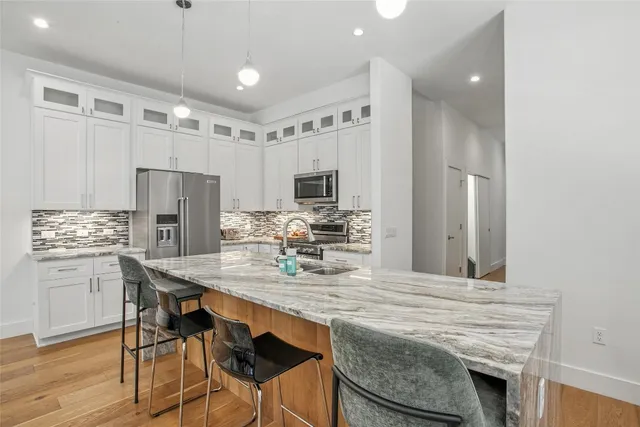 a kitchen with kitchen island a refrigerator stove microwave and cabinets