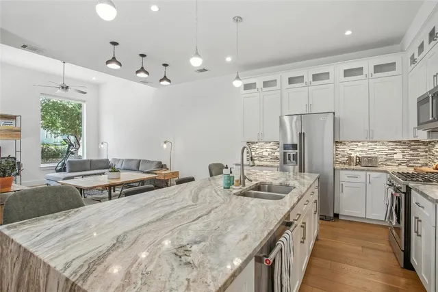 a kitchen with stainless steel appliances granite countertop a sink dishwasher and cabinets with wooden floor