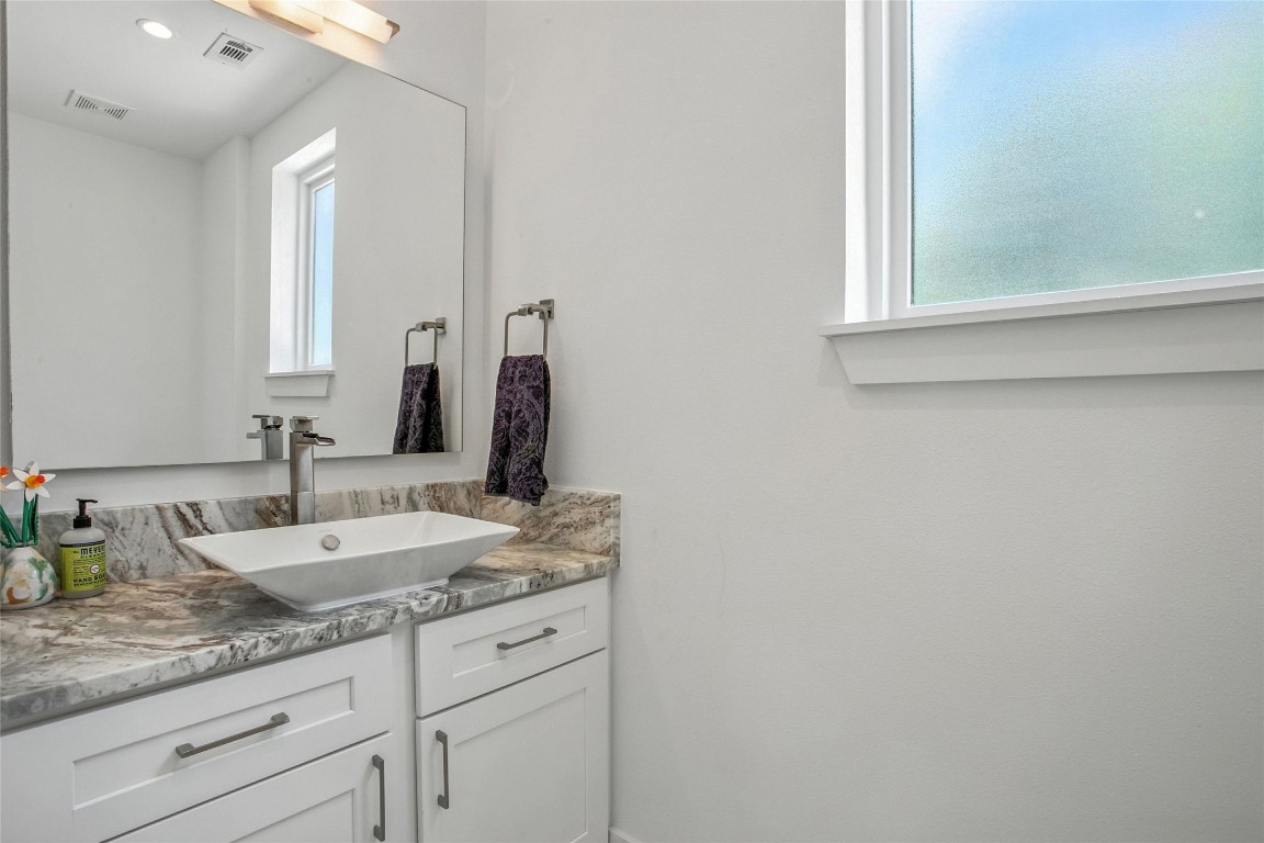 5402 Woodrow Avenue, Unit B Austin, TX 78756 - Photo 19 of 36 a bathroom with a granite countertop sink and a mirror