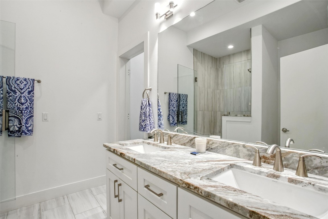 5402 Woodrow Avenue, Unit B Austin, TX 78756 - Photo 24 of 36 a bathroom with a granite countertop double vanity sink and a mirror