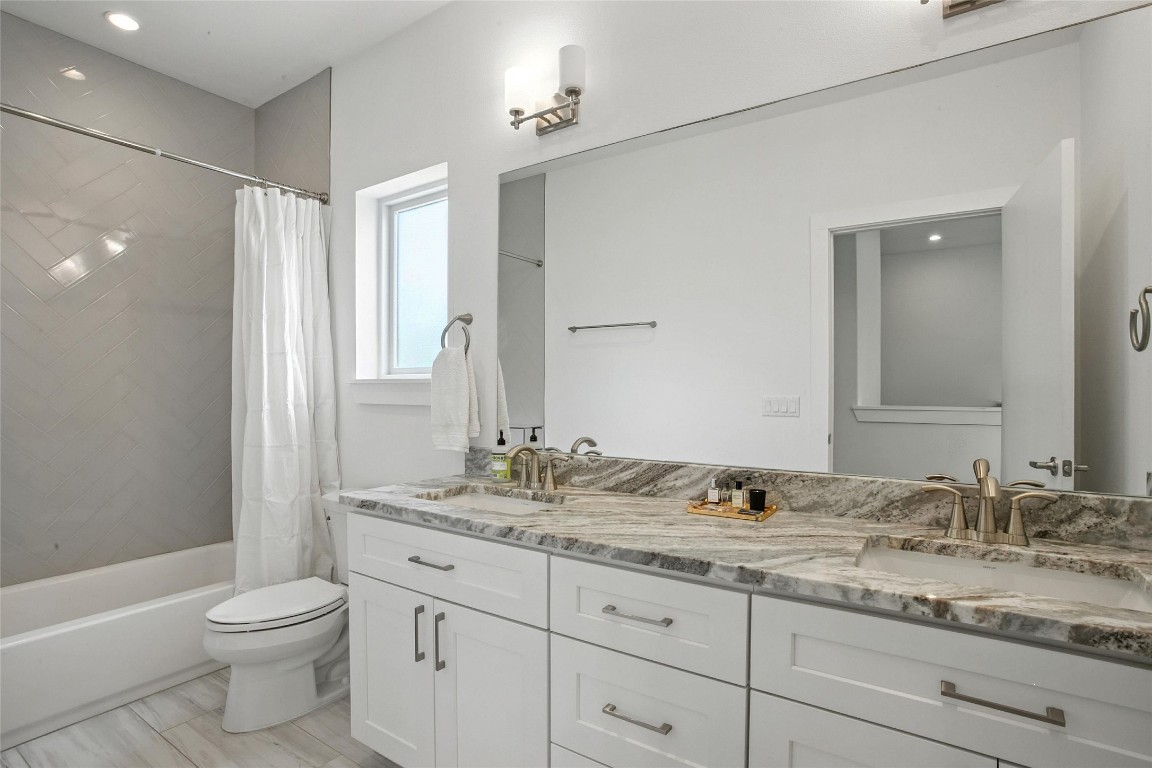 5402 Woodrow Avenue, Unit B Austin, TX 78756 - Photo 27 of 36 a bathroom with a granite countertop sink toilet mirror and shower