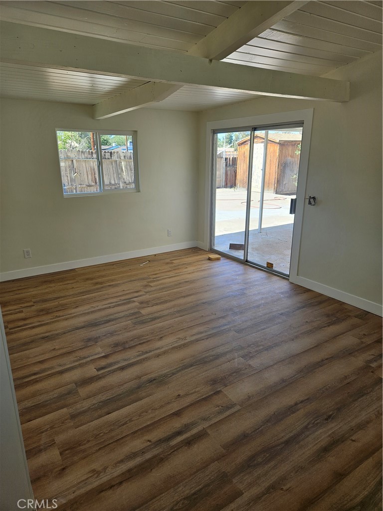 13100 Skiomah Road Apple Valley, CA 92308 - Photo 17 of 19 a view of an empty room with wooden floor and a window