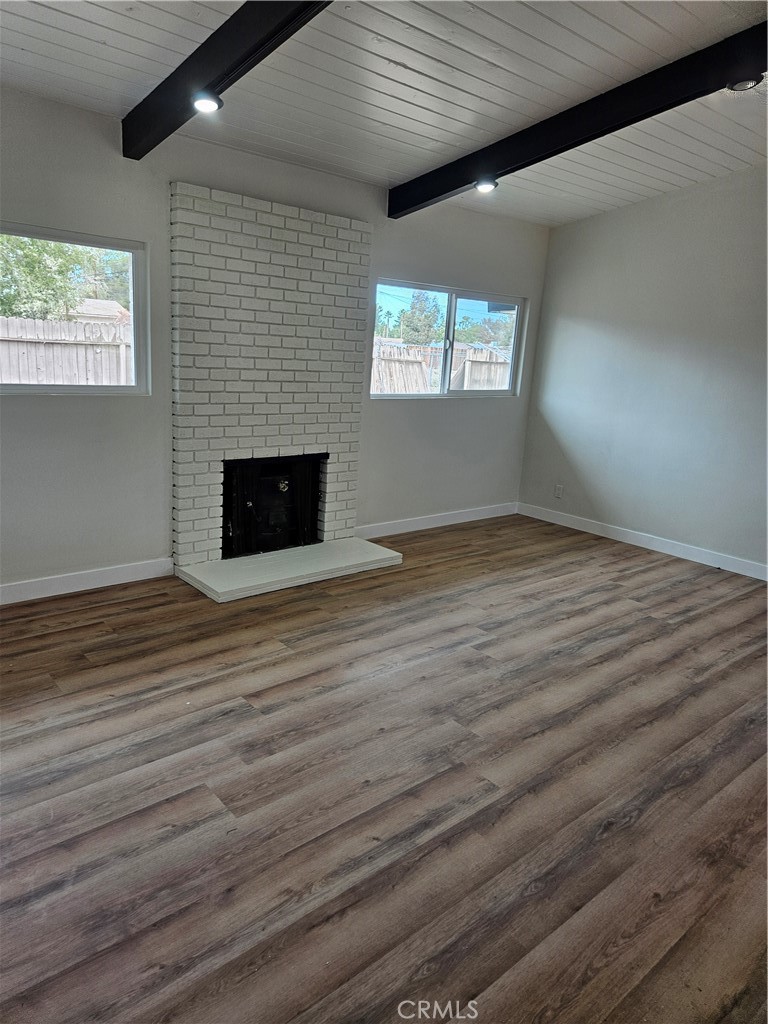 13100 Skiomah Road Apple Valley, CA 92308 - Photo 7 of 19 a view of an empty room with wooden floor and a window