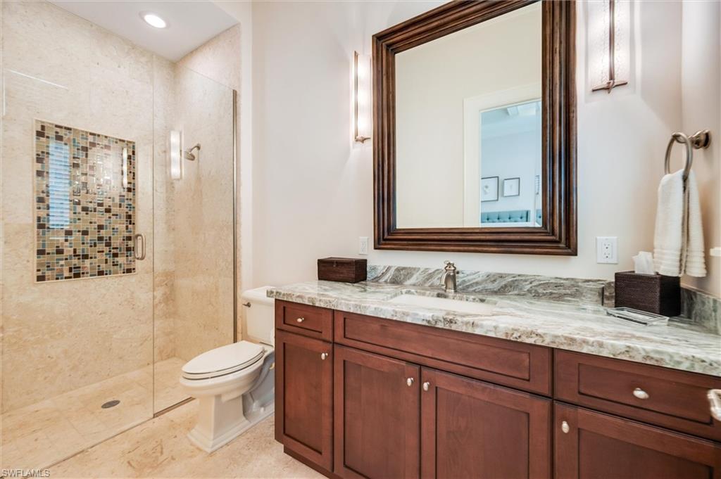 2250 Crayton Road Naples, FL 34103 - Photo 29 of 45 a bathroom with a granite countertop sink mirror vanity and toilet