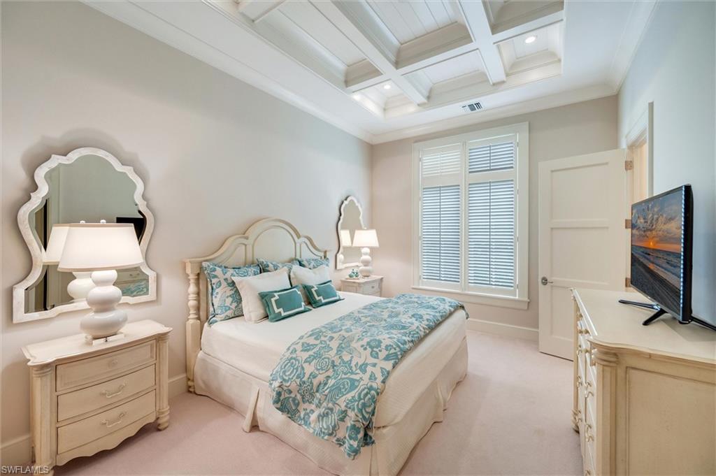2250 Crayton Road Naples, FL 34103 - Photo 33 of 45 a bedroom with a bed and a flat tv screen on the dresser