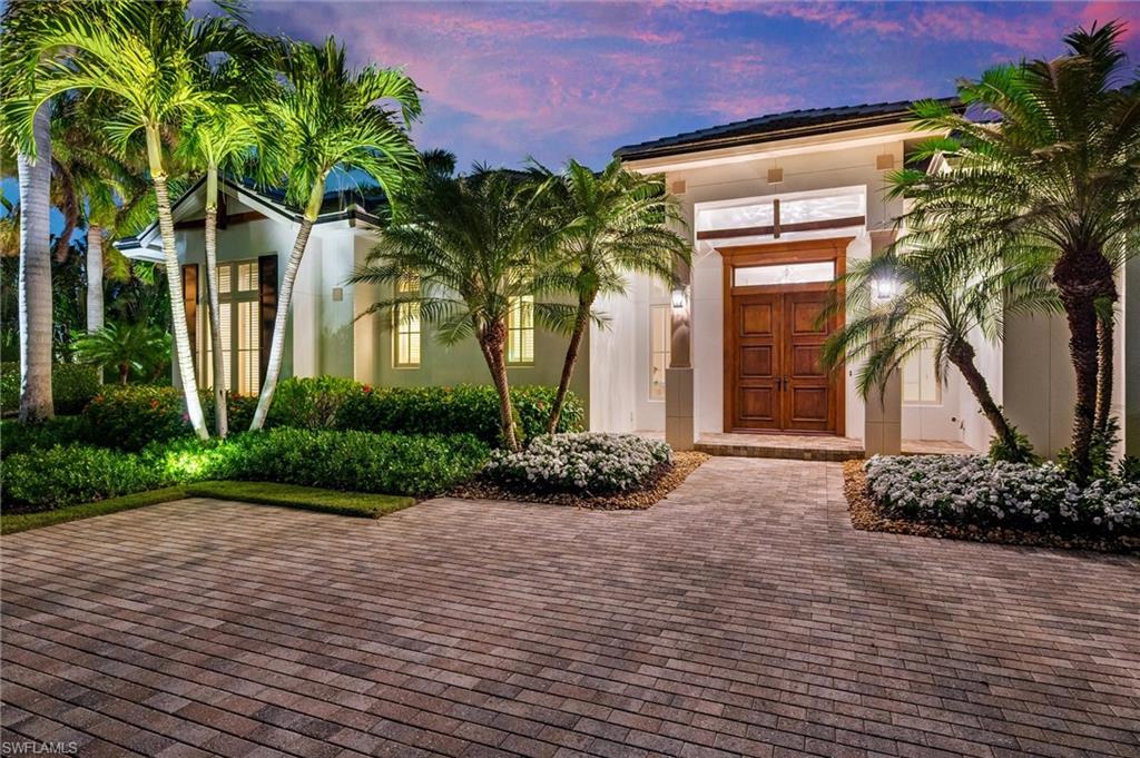 2250 Crayton Road Naples, FL 34103 - Photo 4 of 45 a front view of a house with a yard and a garage
