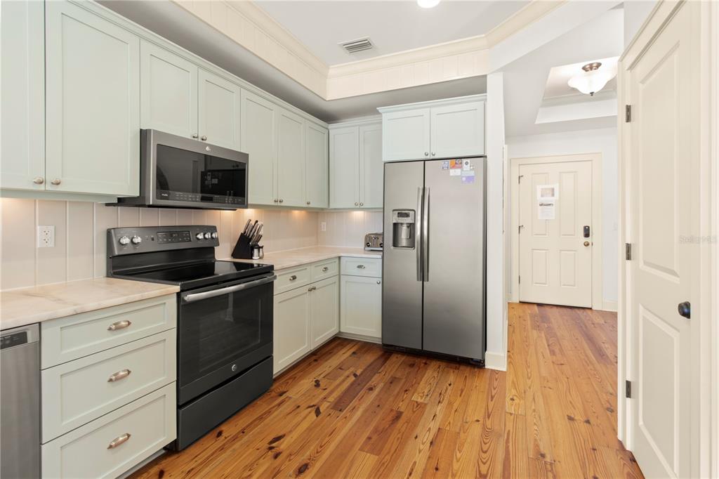 101 66th Street, Unit 6 Holmes Beach, FL 34217 - Photo 20 of 48 a kitchen with a refrigerator stove and white cabinets