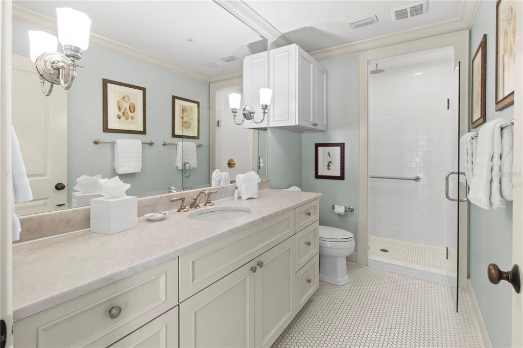 101 66th Street, Unit 6 Holmes Beach, FL 34217 - Photo 33 of 48 a spacious bathroom with a double vanity sink toilet mirror and shower
