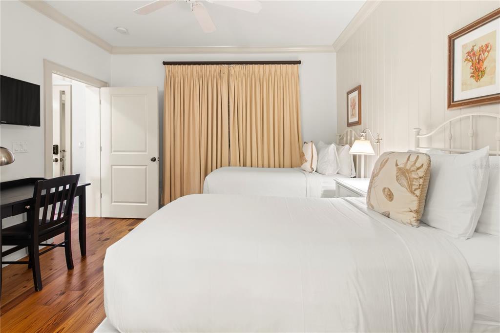 101 66th Street, Unit 6 Holmes Beach, FL 34217 - Photo 38 of 48 a bedroom with a bed a table and chair