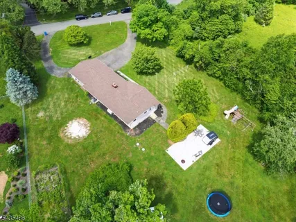 an aerial view of a house with a yard and green space