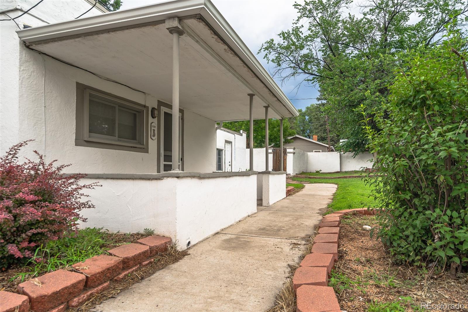 1118 East Platte Avenue, Unit B Colorado Springs, CO 80903 - Photo 1 of 15 a front view of a house with garden