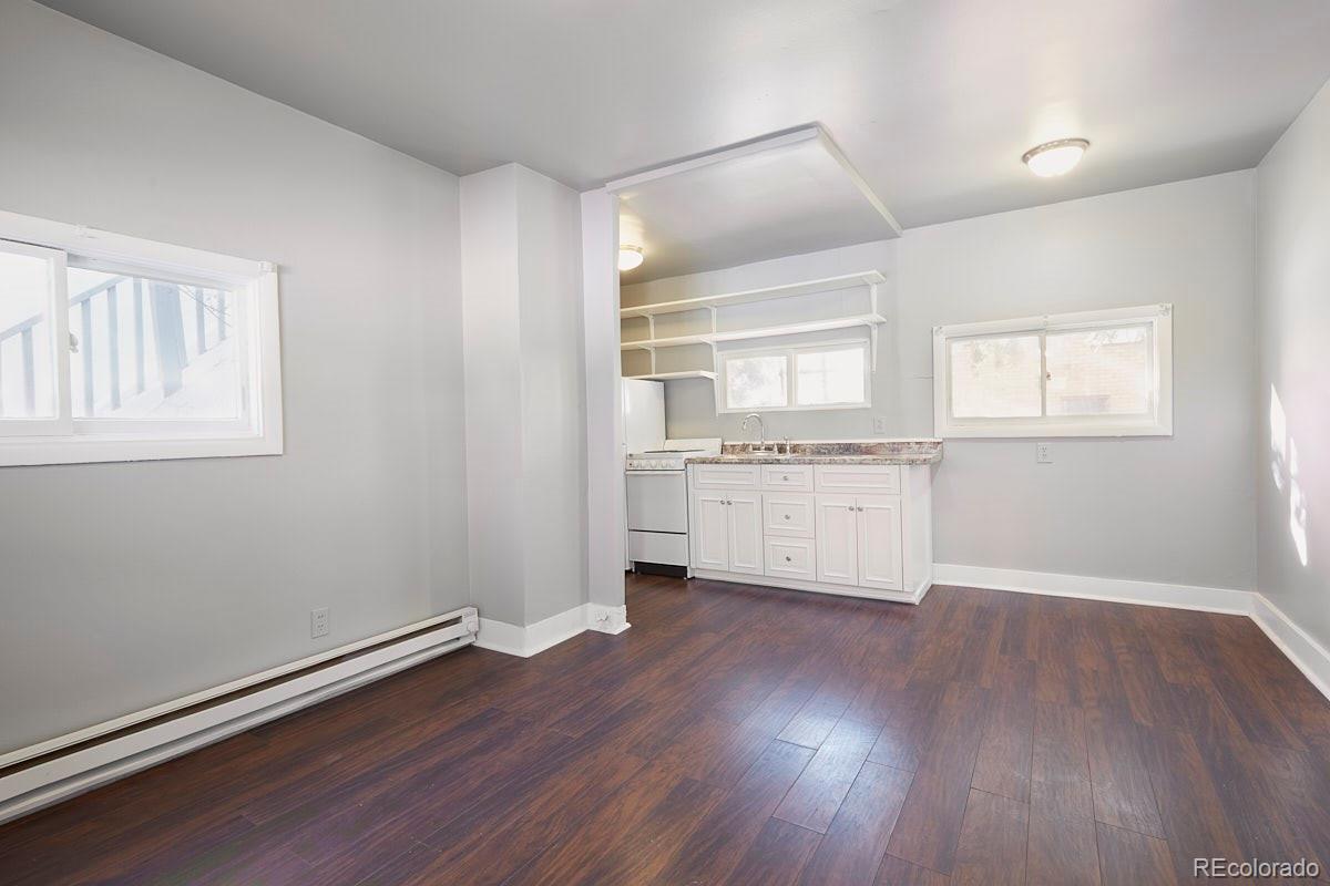 1118 East Platte Avenue, Unit B Colorado Springs, CO 80903 - Photo 3 of 15 an empty room with wooden floor and windows