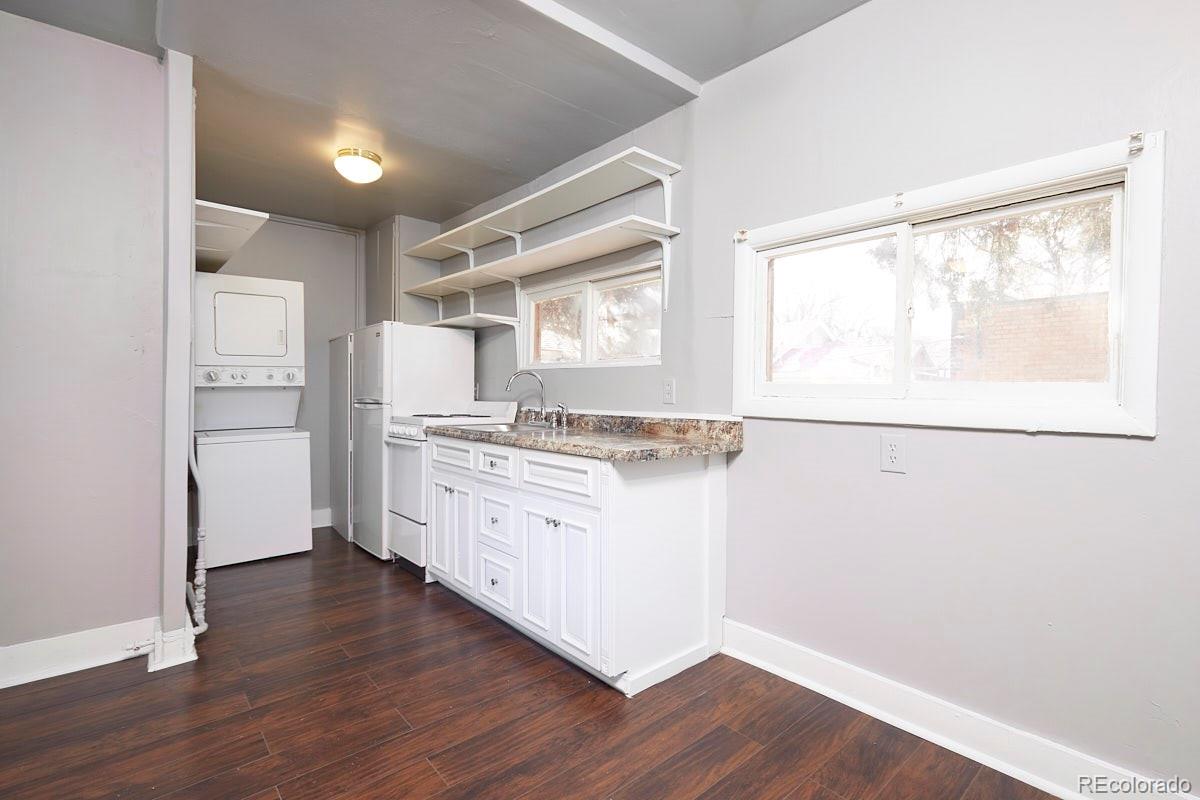 1118 East Platte Avenue, Unit B Colorado Springs, CO 80903 - Photo 5 of 15 a kitchen with granite countertop white cabinets and wooden floor