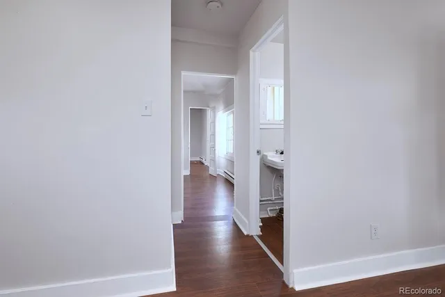 a view of a hallway with wooden floor and closet