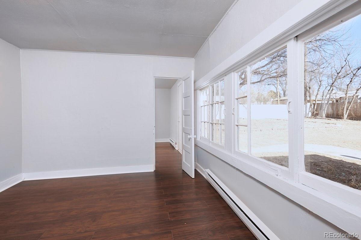 1118 East Platte Avenue, Unit B Colorado Springs, CO 80903 - Photo 10 of 15 a view of an empty room with wooden floor and a window