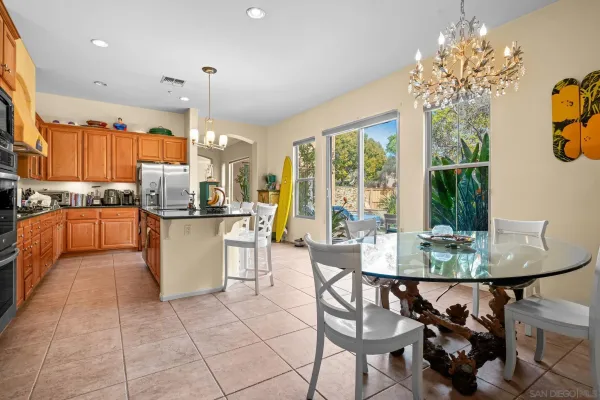 a dining room filled chandelier and kitchen view