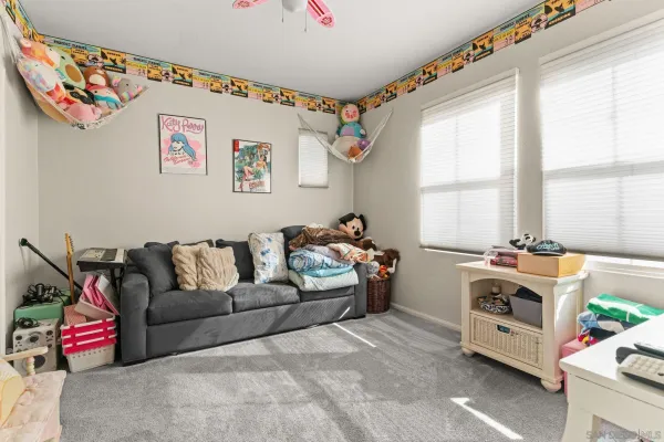 a living room with furniture a flat screen tv and a window