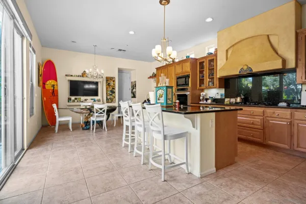 a kitchen with stainless steel appliances a dining table chairs and a chandelier