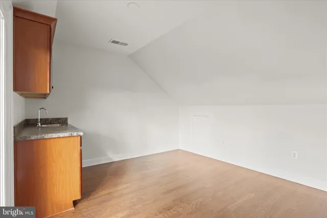 a view of a small space with wooden floor and a sink