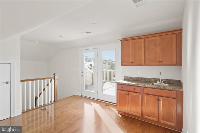 a kitchen with granite countertop a sink window and cabinets