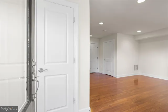an empty room with wooden floor and white doors