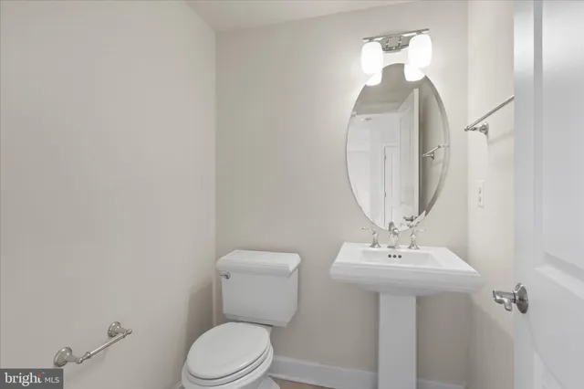 a bathroom with a toilet a sink and mirror
