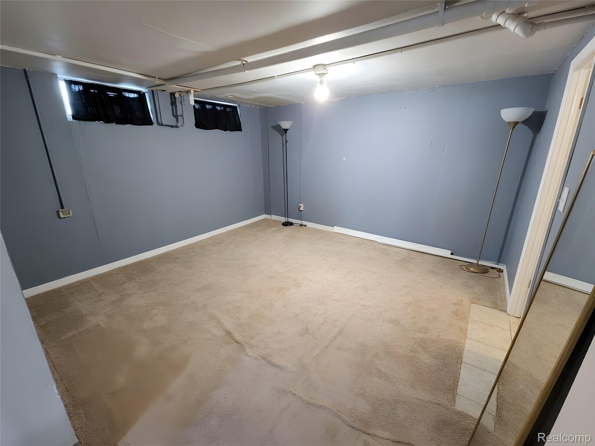 9921 Middlebelt Road, Unit 32 Livonia, MI 48150 - Photo 10 of 11 Carpeted room with painted blue walls, white trim, and two elevated windows