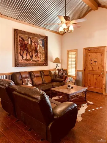 a living room with furniture a chandelier and a large window