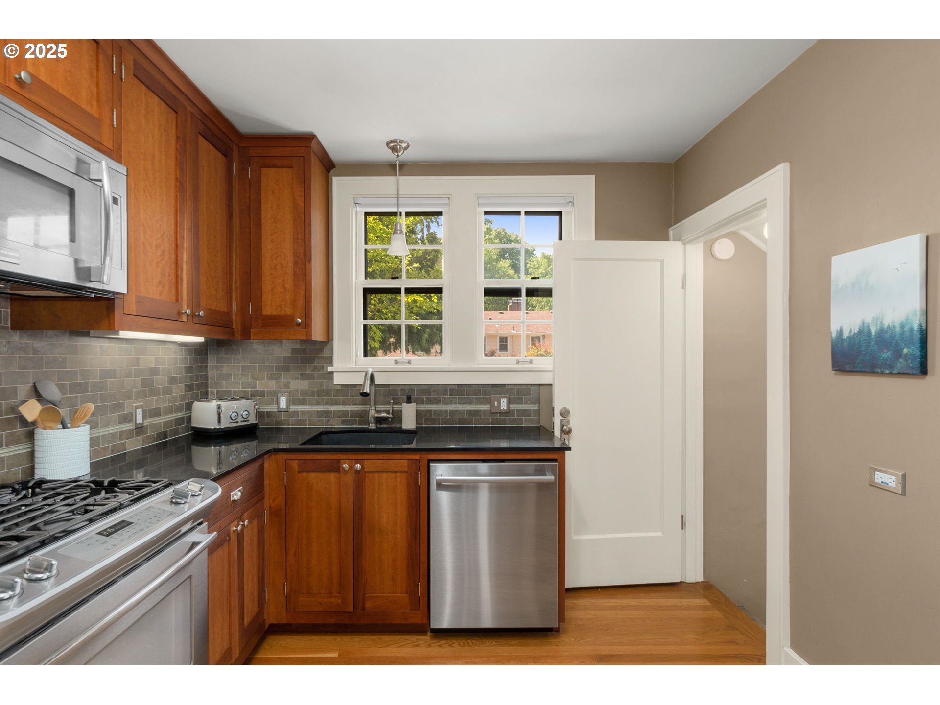 6807 Southeast 34th Avenue Portland, OR 97202 - Photo 11 of 39 a kitchen with stainless steel appliances granite countertop a refrigerator and a stove top oven