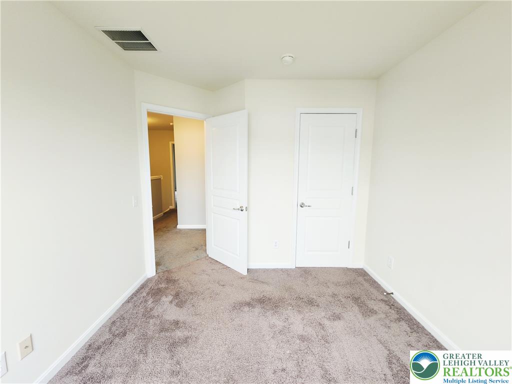 8513 Gateway Road Breinigsville, PA 18031 - Photo 37 of 45 A well-lit bedroom features plush carpeting and classic white doors.