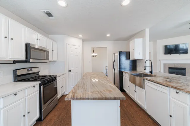 a kitchen with a sink appliances and dining table