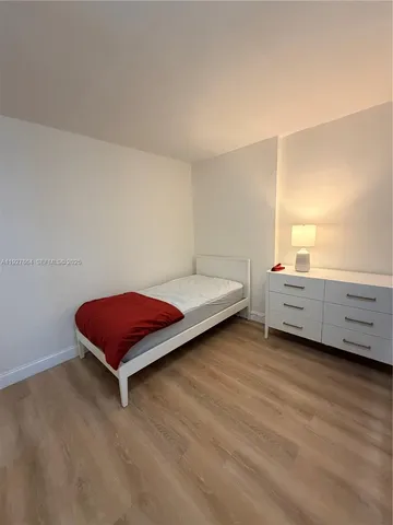 a bedroom with a bed and a night stand