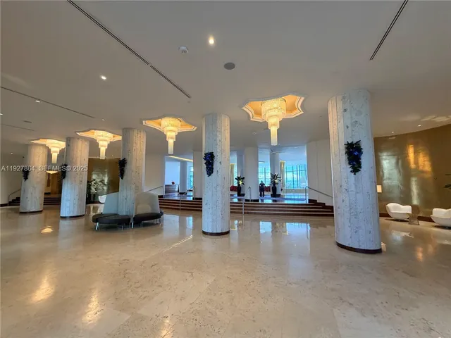 a lobby with furniture and a large mirror