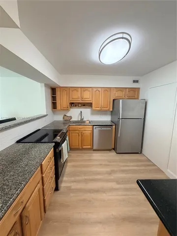 a kitchen with a stove top oven and cabinets