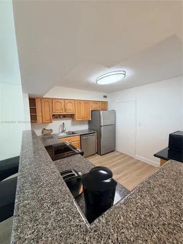 a large bedroom with a bed and wooden floor