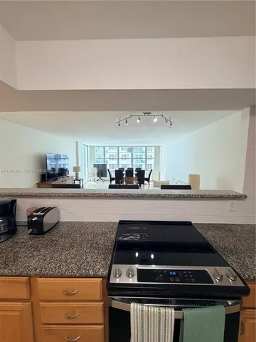 a kitchen with granite countertop a sink and cabinets