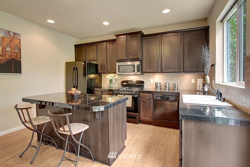 325 Field Place Northeast Renton, WA 98059 - Photo 5 of 13 a kitchen with kitchen island granite countertop wooden cabinets and a stainless steel appliances