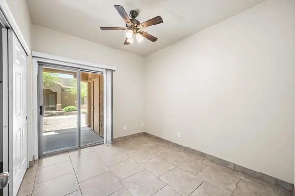 an empty room with a ceiling fan and a glass door shower