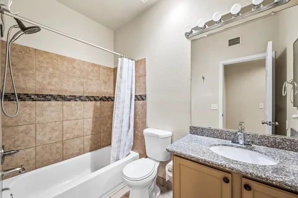 a bathroom with a granite countertop sink toilet and shower