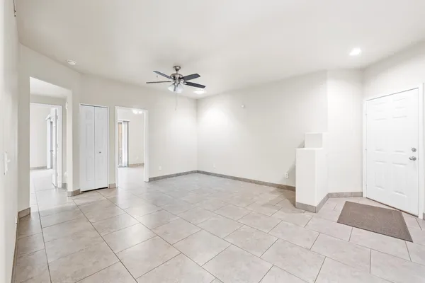 an empty room with a ceiling fan and carpet