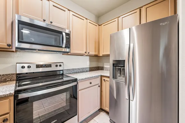 a kitchen with stainless steel appliances white cabinets white stove and a microwave