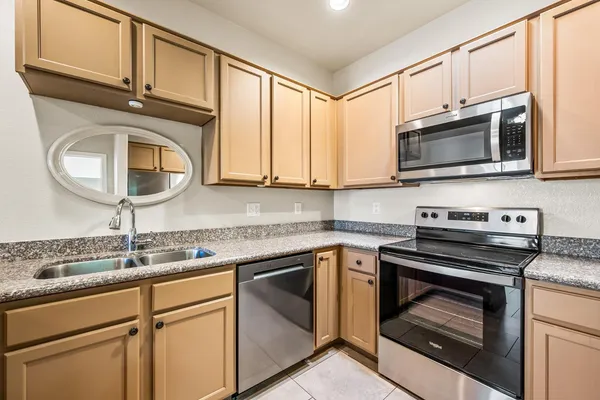 a kitchen with cabinets stainless steel appliances a sink and a microwave