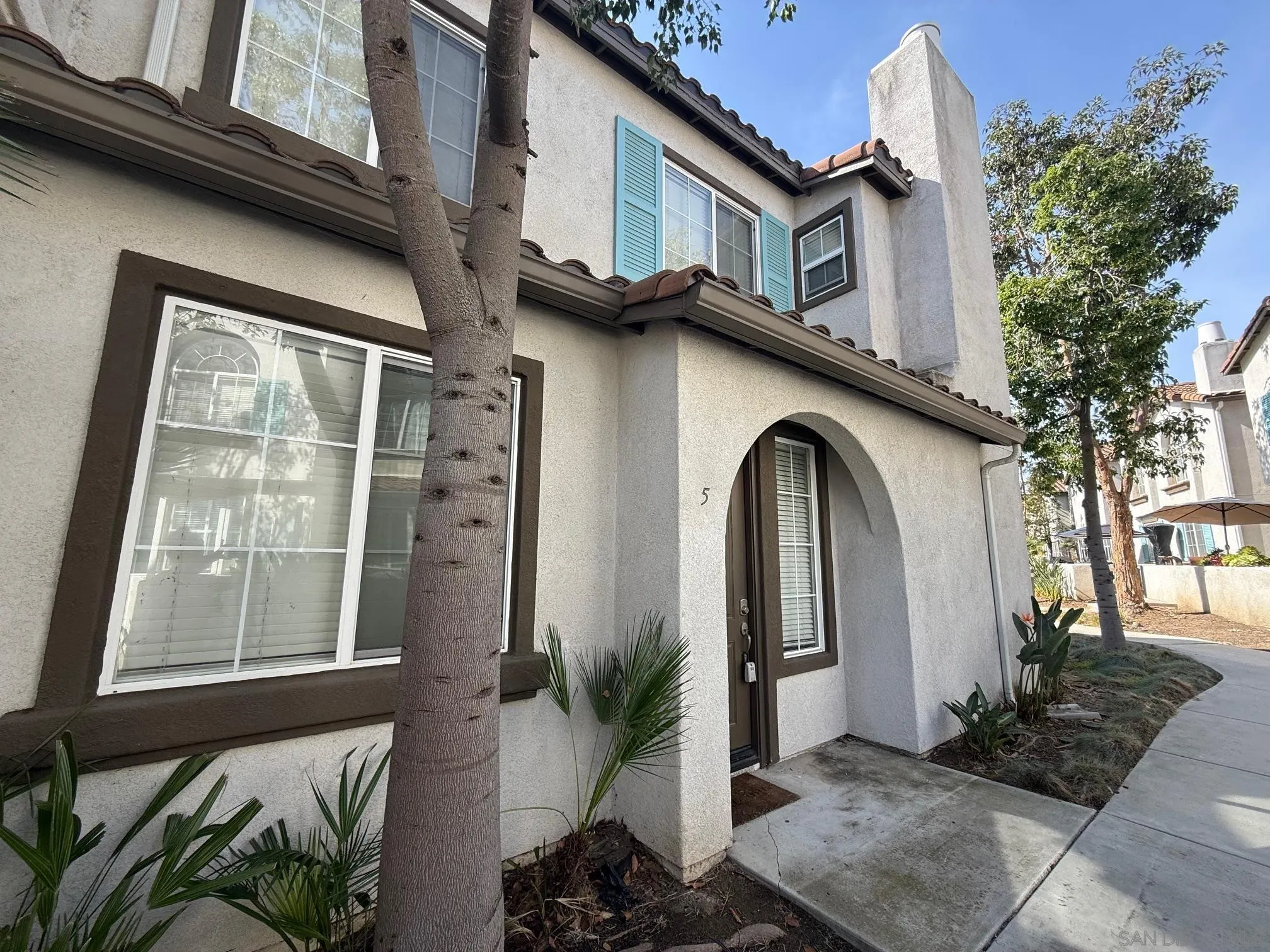 293 Reef Point Way, Unit 5 Oceanside, CA 92058 - Photo 2 of 20 a front view of a house with garden