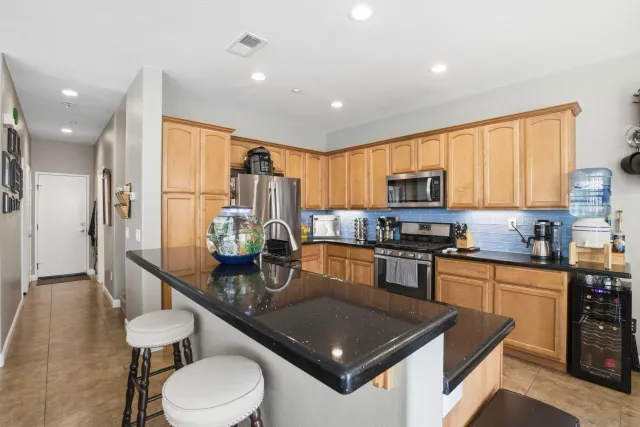 a kitchen with stainless steel appliances granite countertop a kitchen island hardwood floor sink stove and granite counter top