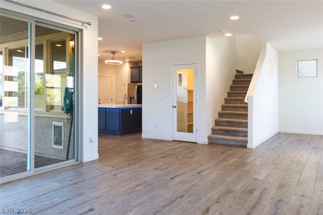 920 East Sunset Road Henderson, NV 89011 - Photo 33 of 33 An open floorplan seamlessly connects the kitchen, living space, and staircase, offering clear views to the outdoors through sliding doors.